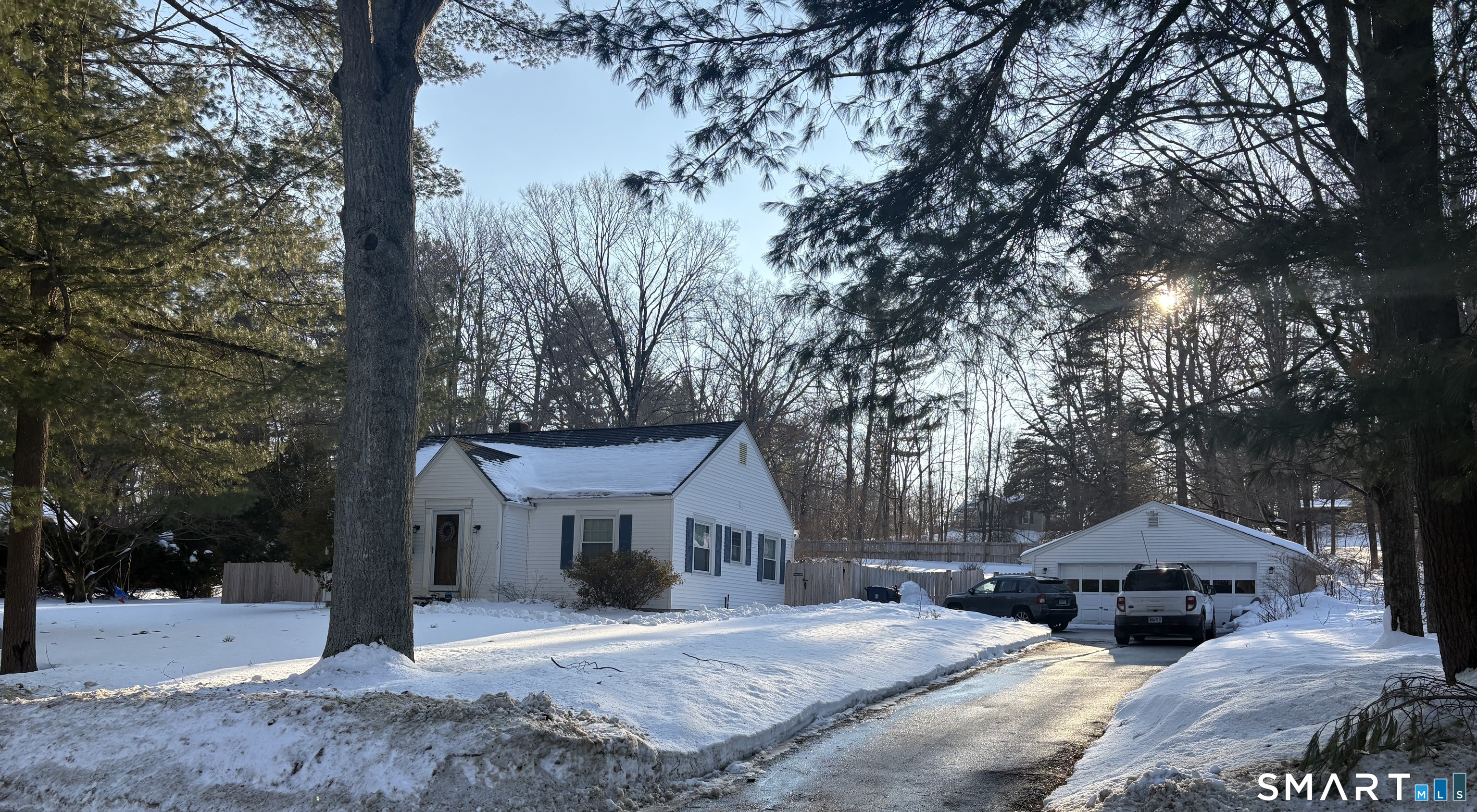a front view of a house with a yard and large tree