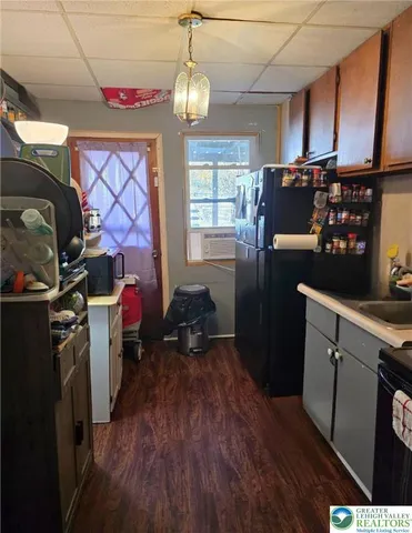 a kitchen with a refrigerator wooden floor and a sink