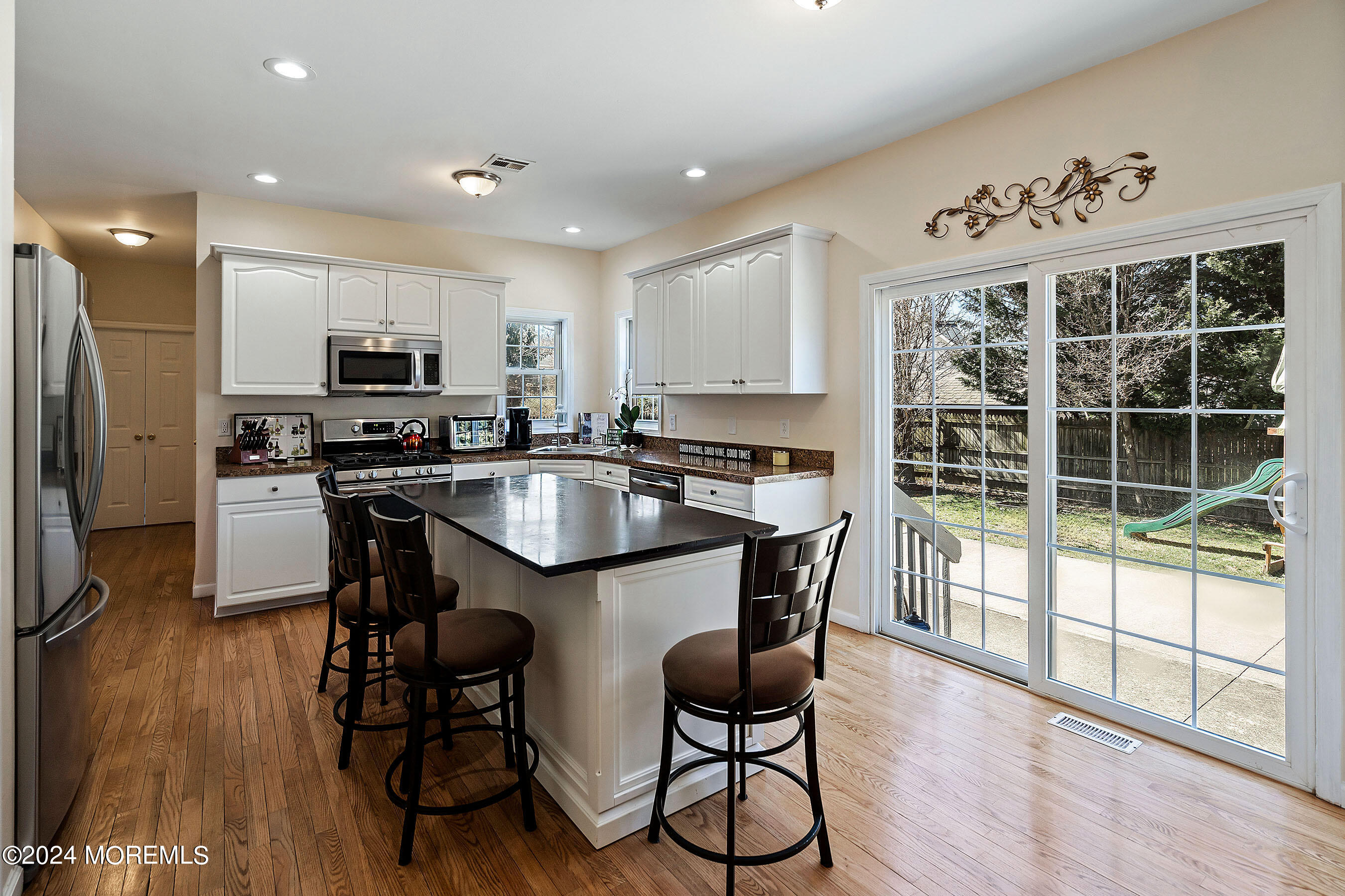 1415 Dorset Dock Road Point Pleasant, NJ 08742 - Photo 8 of 27 a kitchen with granite countertop a stove a sink a microwave a dining table and chairs