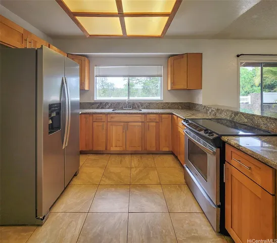 a kitchen with stainless steel appliances granite countertop a stove a sink and a refrigerator