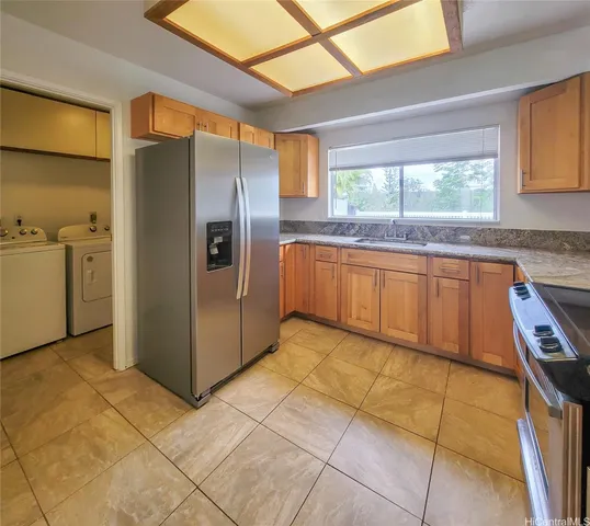 a kitchen with stainless steel appliances granite countertop a refrigerator and a sink