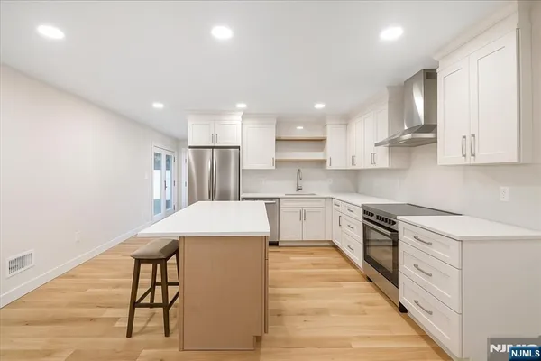 a kitchen with cabinets and wooden floor