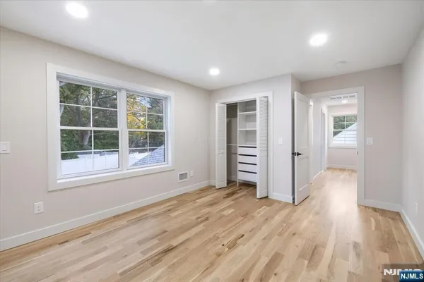 a view of empty room with wooden floor and windows