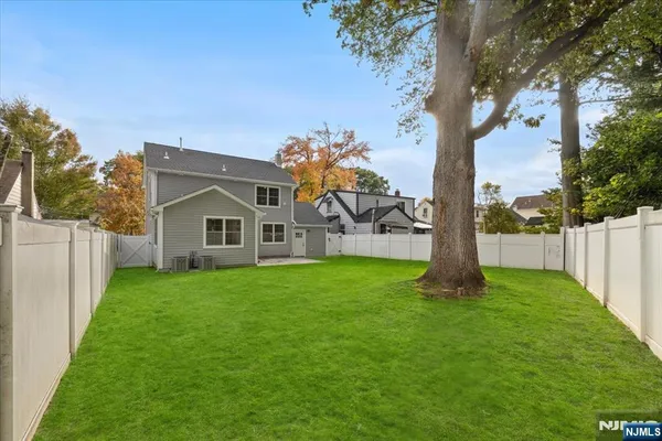 a view of a house with backyard and a tree