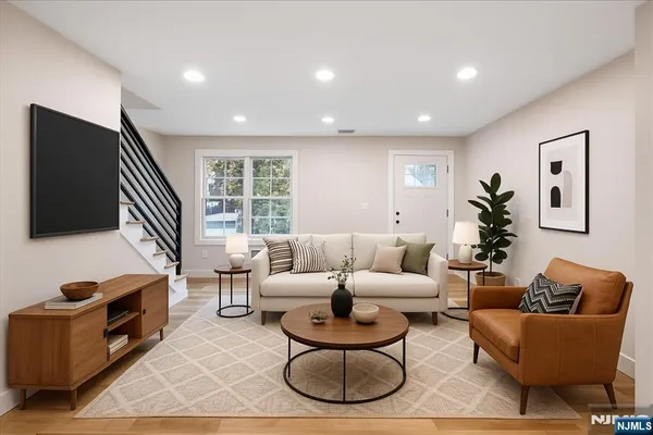 a living room with furniture a flat screen tv and a window
