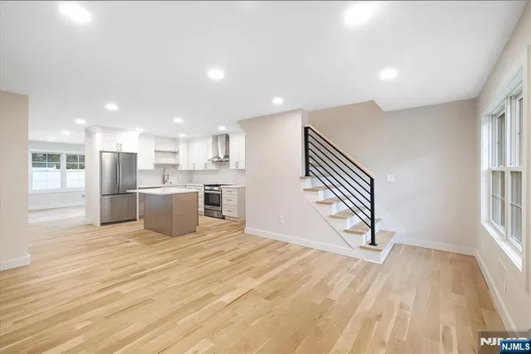 a view of a kitchen with wooden floor and electronic appliances
