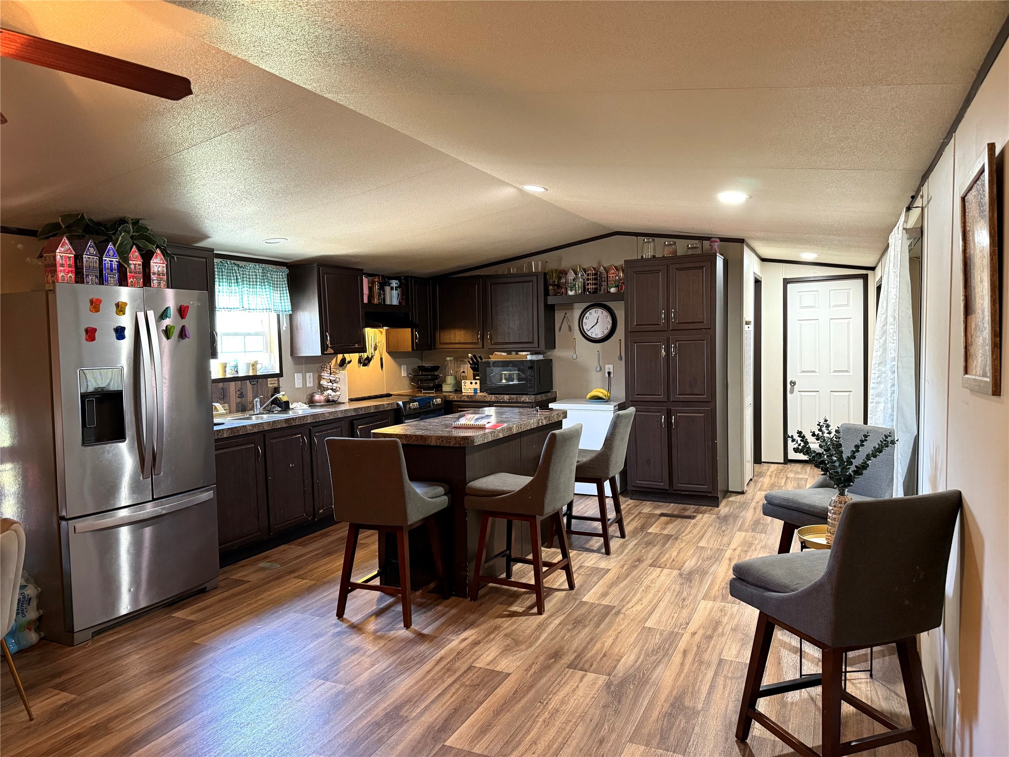 485 County Road 377 Cleveland, TX 77327 - Photo 7 of 16 a kitchen with stainless steel appliances granite countertop a refrigerator a sink dishwasher a dining table and chairs with wooden floor