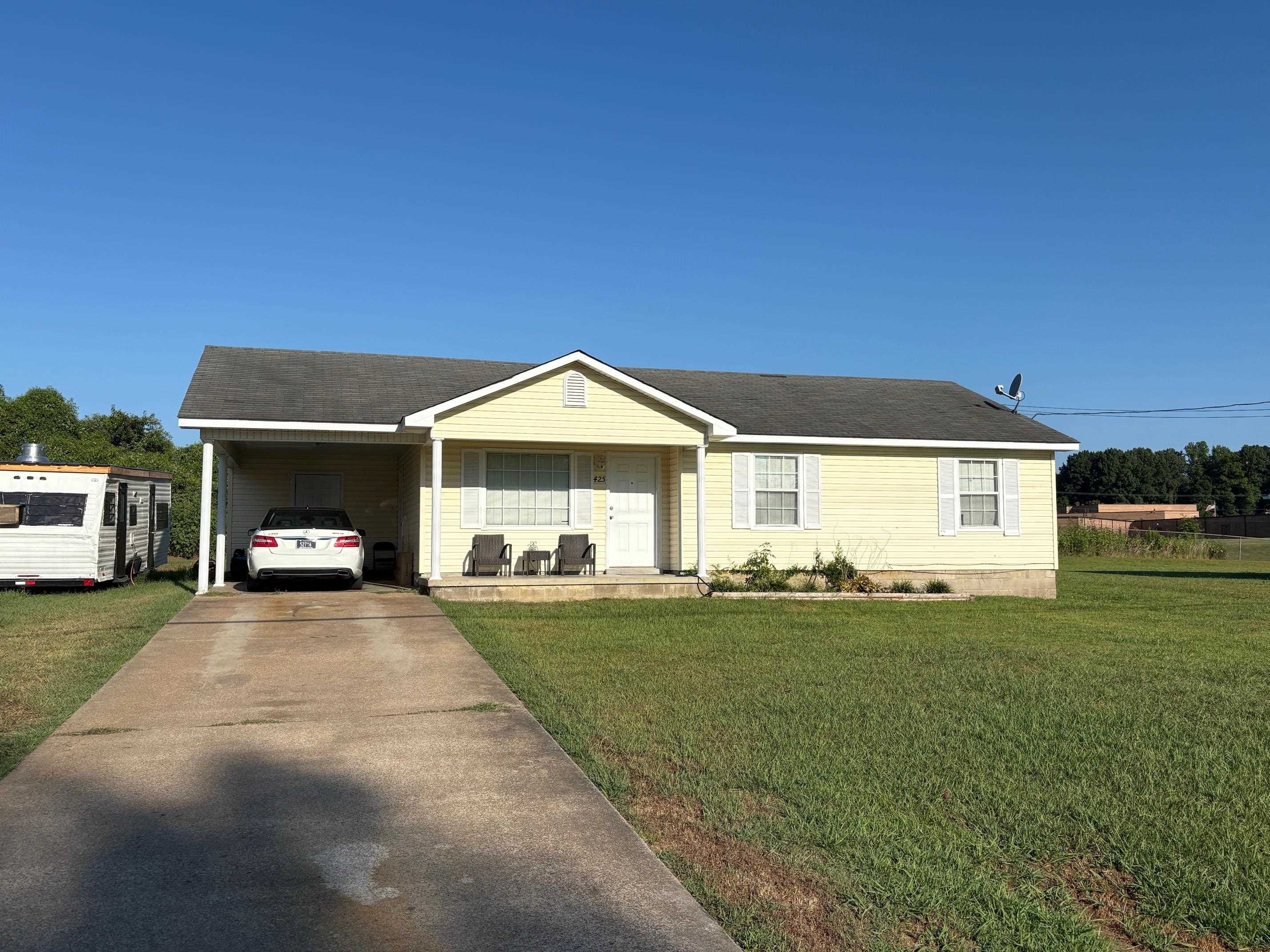 425 Charles Griggs Street Ripley, TN 38063 - Photo 1 of 1 Ranch-style home featuring covered porch, an attached carport, a front yard, driveway, and a shingled roof