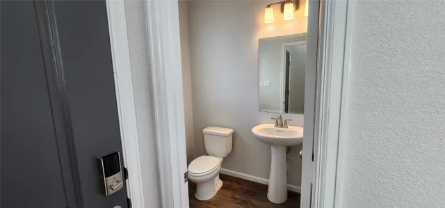 a bathroom with a toilet a sink and mirror