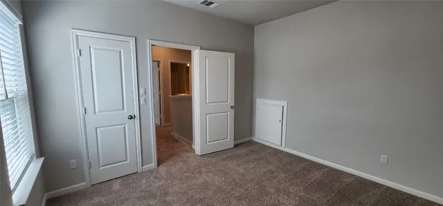 an empty room with closet and wooden door
