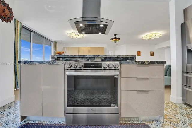 a kitchen with stainless steel appliances a stove a sink dishwasher a refrigerator and white cabinets with wooden floor