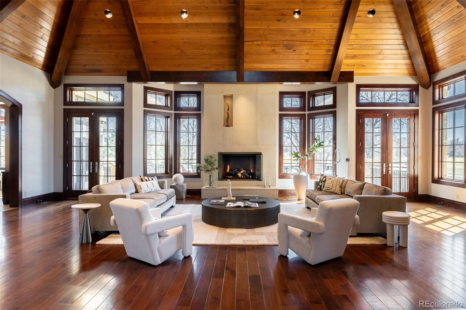 a living room with furniture large window and wooden floor