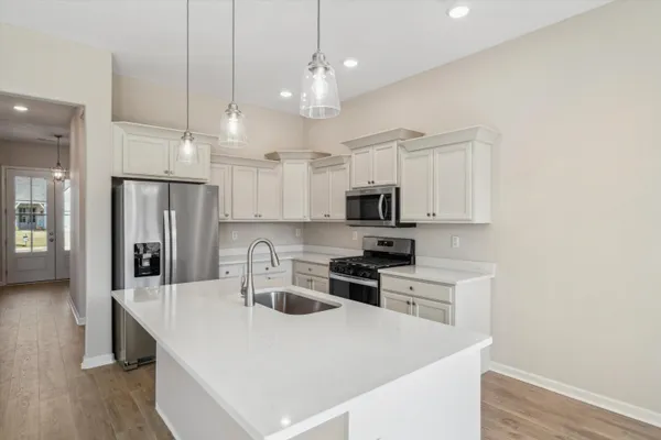 a kitchen with stainless steel appliances a kitchen island a sink a refrigerator and cabinets
