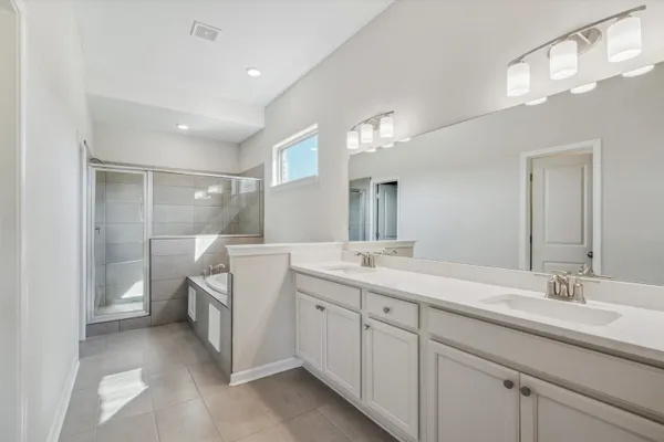 a spacious bathroom with a double vanity sink and mirror
