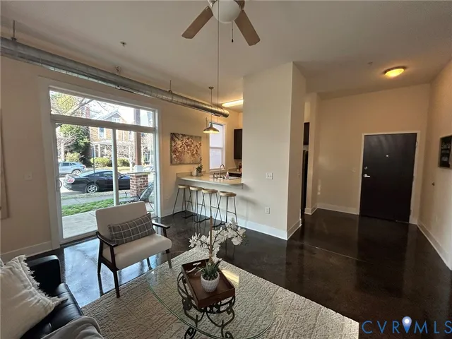 a living room with furniture and a floor to ceiling window