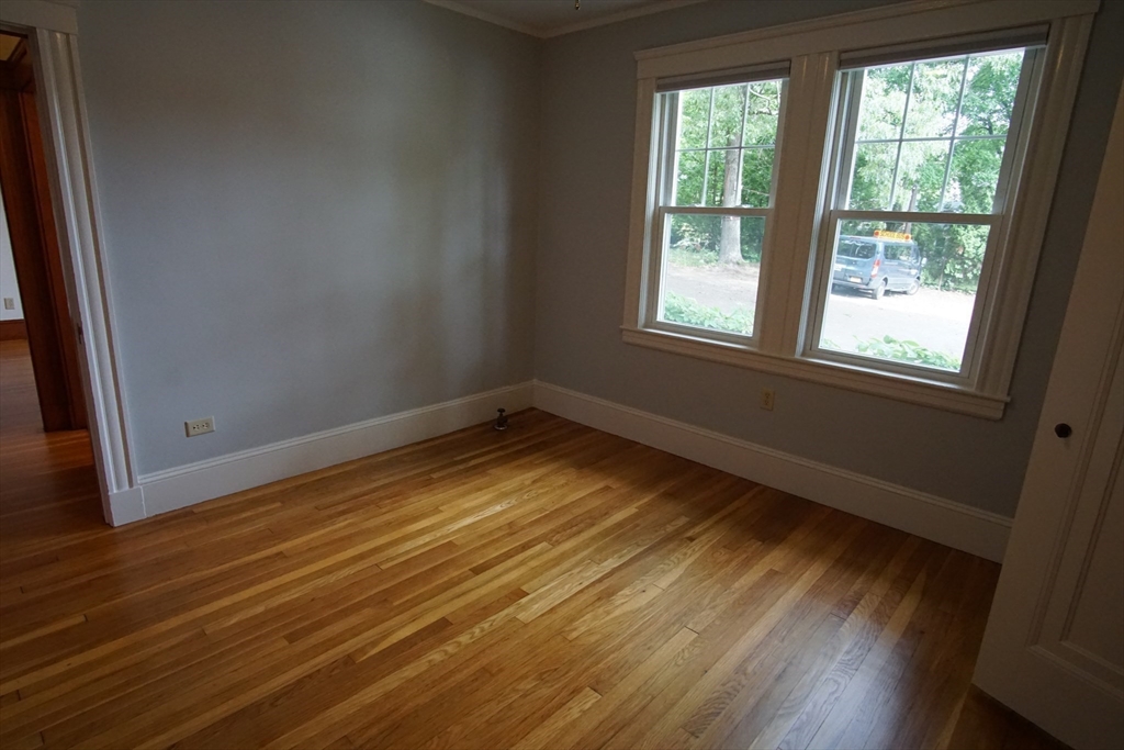 754 Massachusetts Avenue, Unit 1 Lexington, MA 02421 - Photo 14 of 17 an empty room with wooden floor and windows