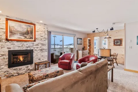 a living room with furniture a fireplace and a large window