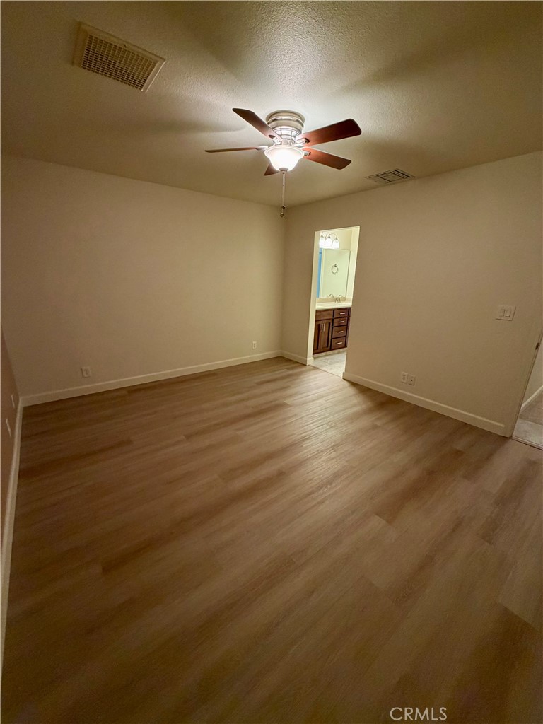 209 Kimberly Lane Ridgecrest, CA 93555 - Photo 53 of 62 an empty room with wooden floor fan and windows