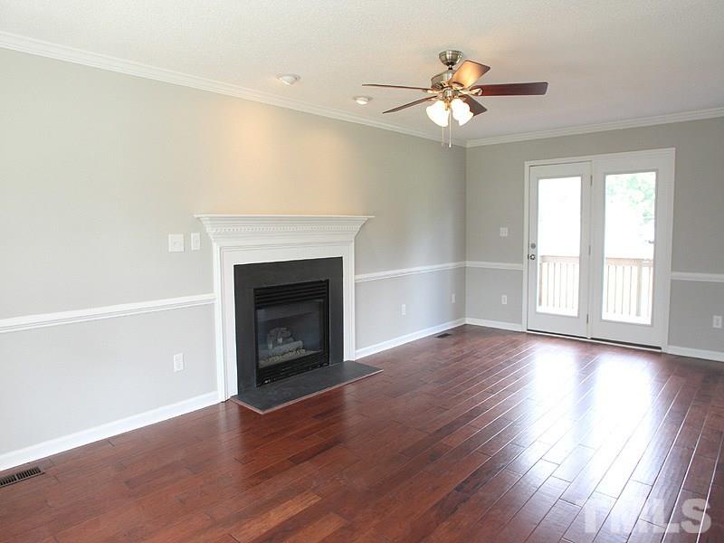 2000 Stoneglen Lane Raleigh, NC 27603 - Photo 13 of 25 a view of an empty room with wooden floor fireplace and a window