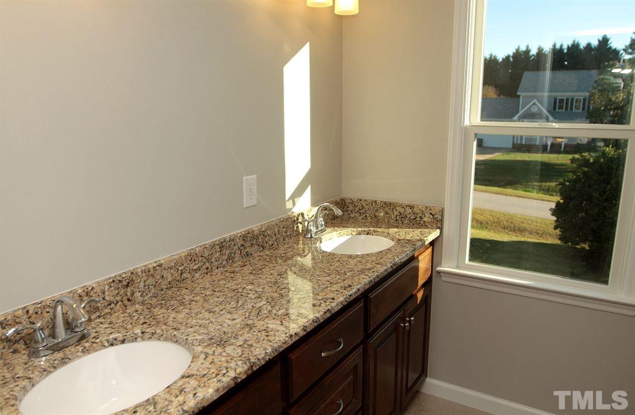 2000 Stoneglen Lane Raleigh, NC 27603 - Photo 17 of 25 a bathroom with a granite countertop sink and a mirror