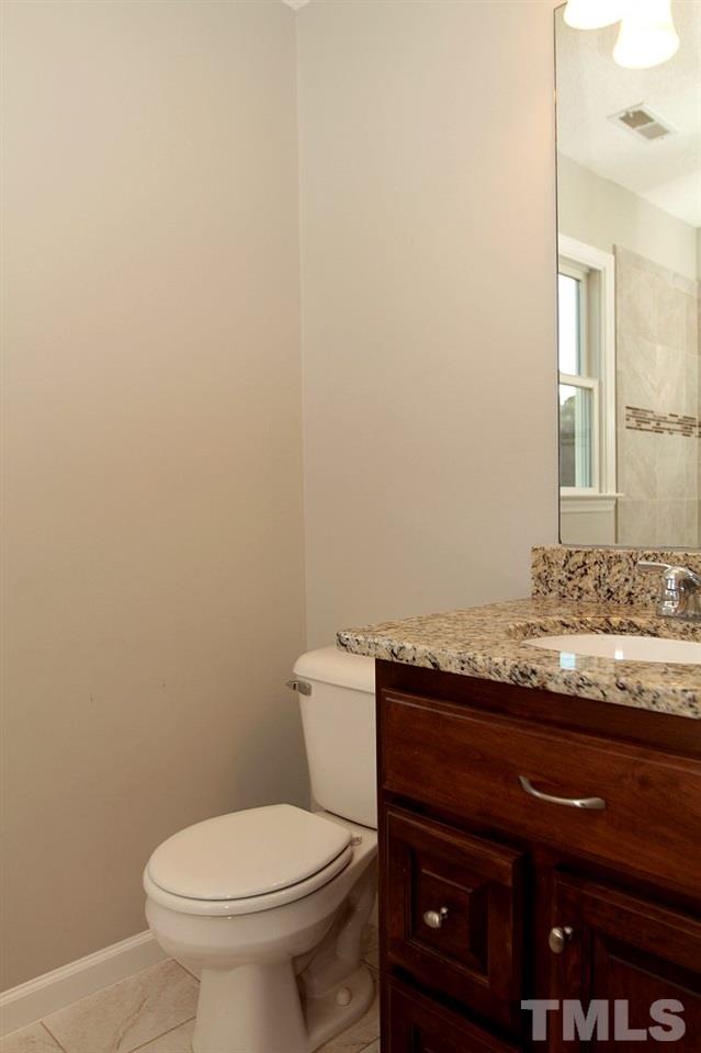 2000 Stoneglen Lane Raleigh, NC 27603 - Photo 21 of 25 a bathroom with a granite countertop toilet and a sink