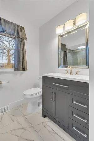 a bathroom with a sink mirror and toilet
