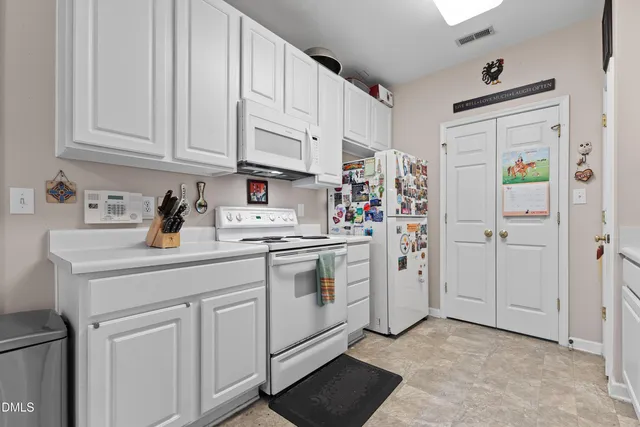 a kitchen with white cabinets and white appliances