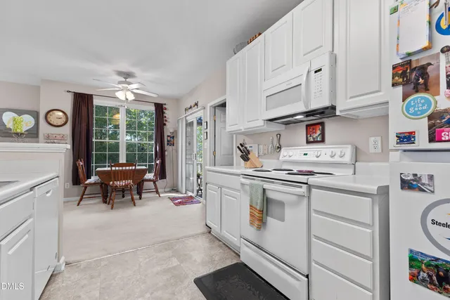 a kitchen with white cabinets and white appliances
