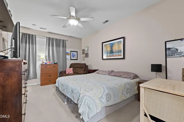 a spacious bedroom with a bed and a chandelier