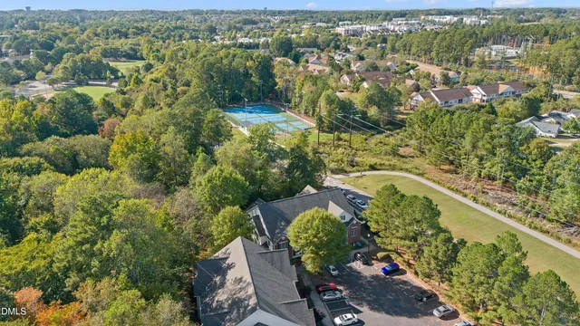 an aerial view of residential house with outdoor space and trees all around
