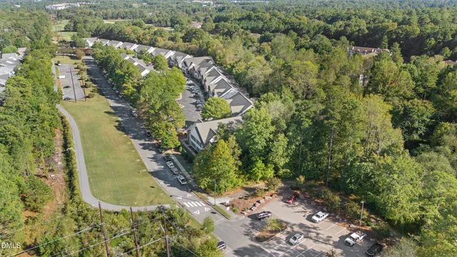an aerial view of a house with a yard and greenery