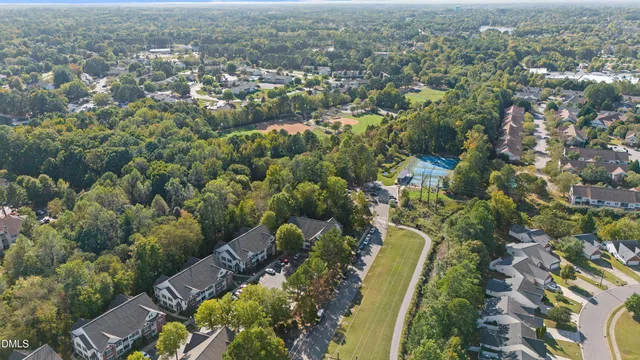 an aerial view of residential house with green space and trees