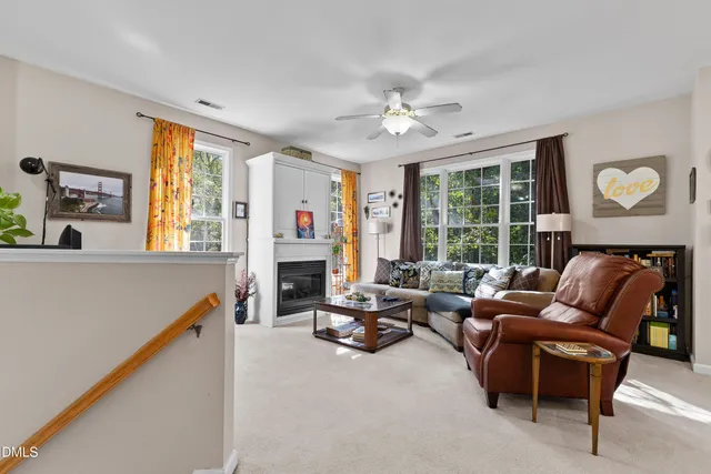 a living room with furniture a fireplace and a large window