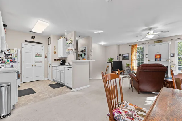 a living room with furniture and a dining table with wooden floor