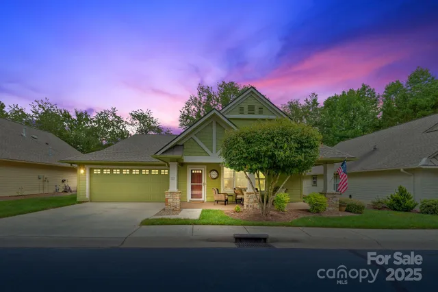 a front view of a house with a garden and a car
