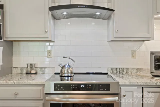 a kitchen with stainless steel appliances granite countertop a refrigerator and a stove top oven