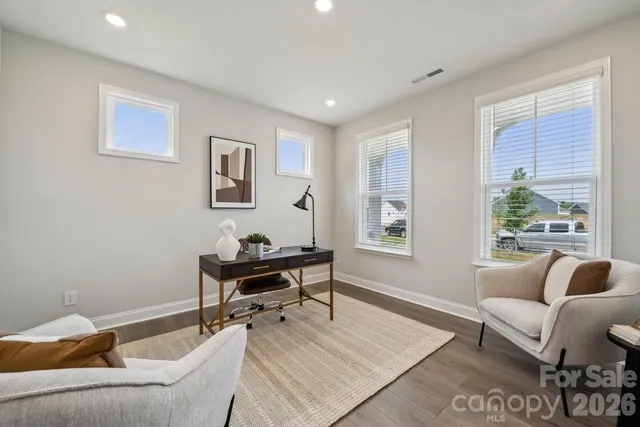 a kitchen with stainless steel appliances granite countertop a refrigerator a oven a sink a stove a dining table and chairs with wooden floor