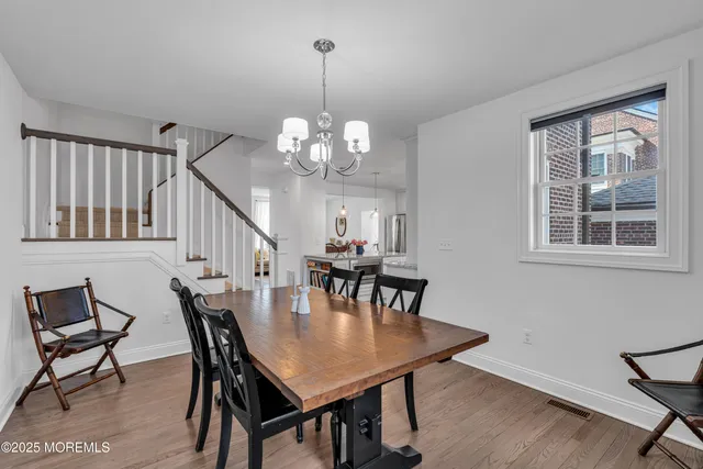 a view of a dining room with furniture a chandelier and wooden floor