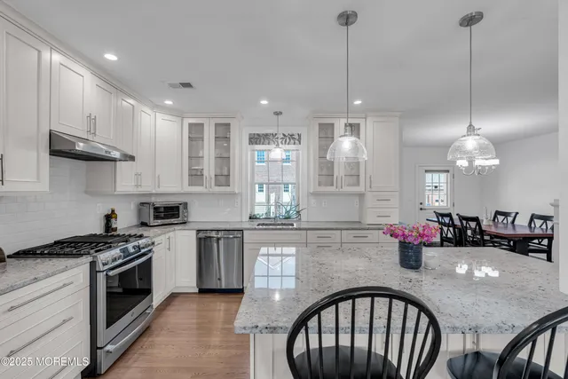 a kitchen with sink a stove and cabinets