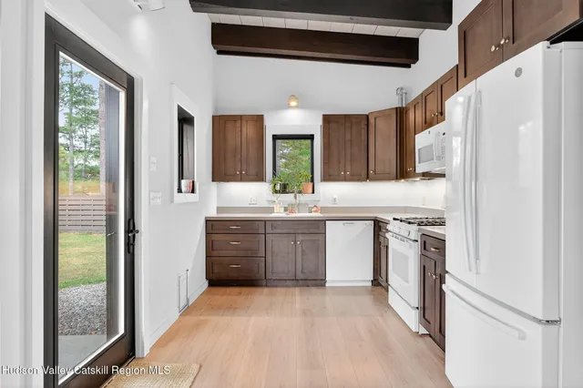 a kitchen with granite countertop a refrigerator stove top oven and sink
