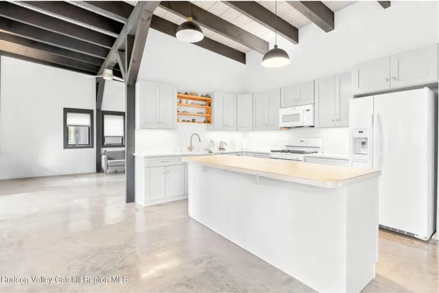 a kitchen with kitchen island white cabinets and refrigerator