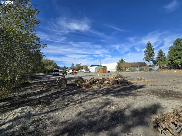 a view of a yard with wooden fence