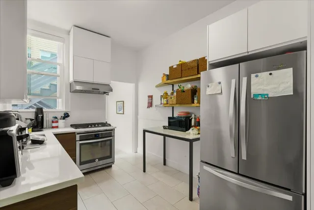 a kitchen with stainless steel appliances granite countertop a refrigerator a stove and a sink with wooden floor