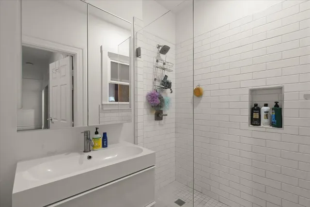 a bathroom with a sink a mirror and shower