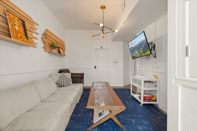 a living room with furniture and a chandelier