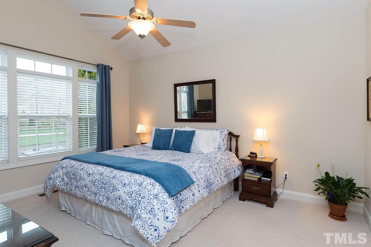650 Democracy Street Raleigh, NC 27603 - Photo 13 of 25 a bedroom with a bed and a chandelier
