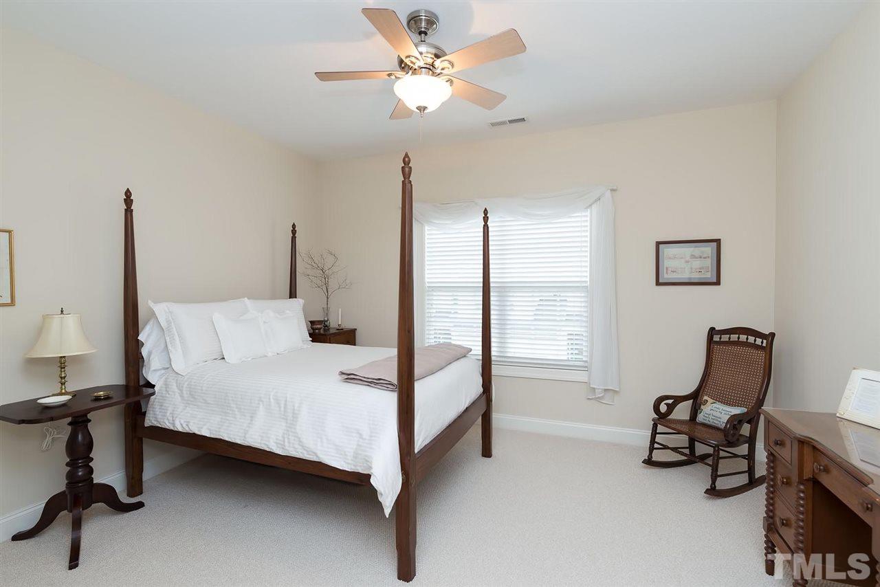 650 Democracy Street Raleigh, NC 27603 - Photo 20 of 25 a bedroom with a bed a chair and a chandelier