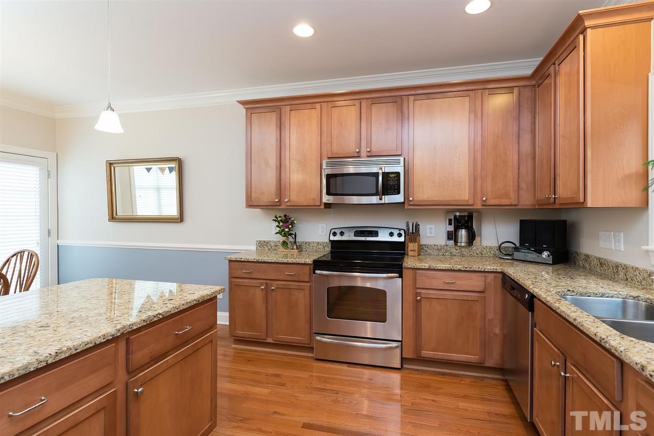 650 Democracy Street Raleigh, NC 27603 - Photo 8 of 25 a kitchen with stainless steel appliances granite countertop a stove a sink and a microwave