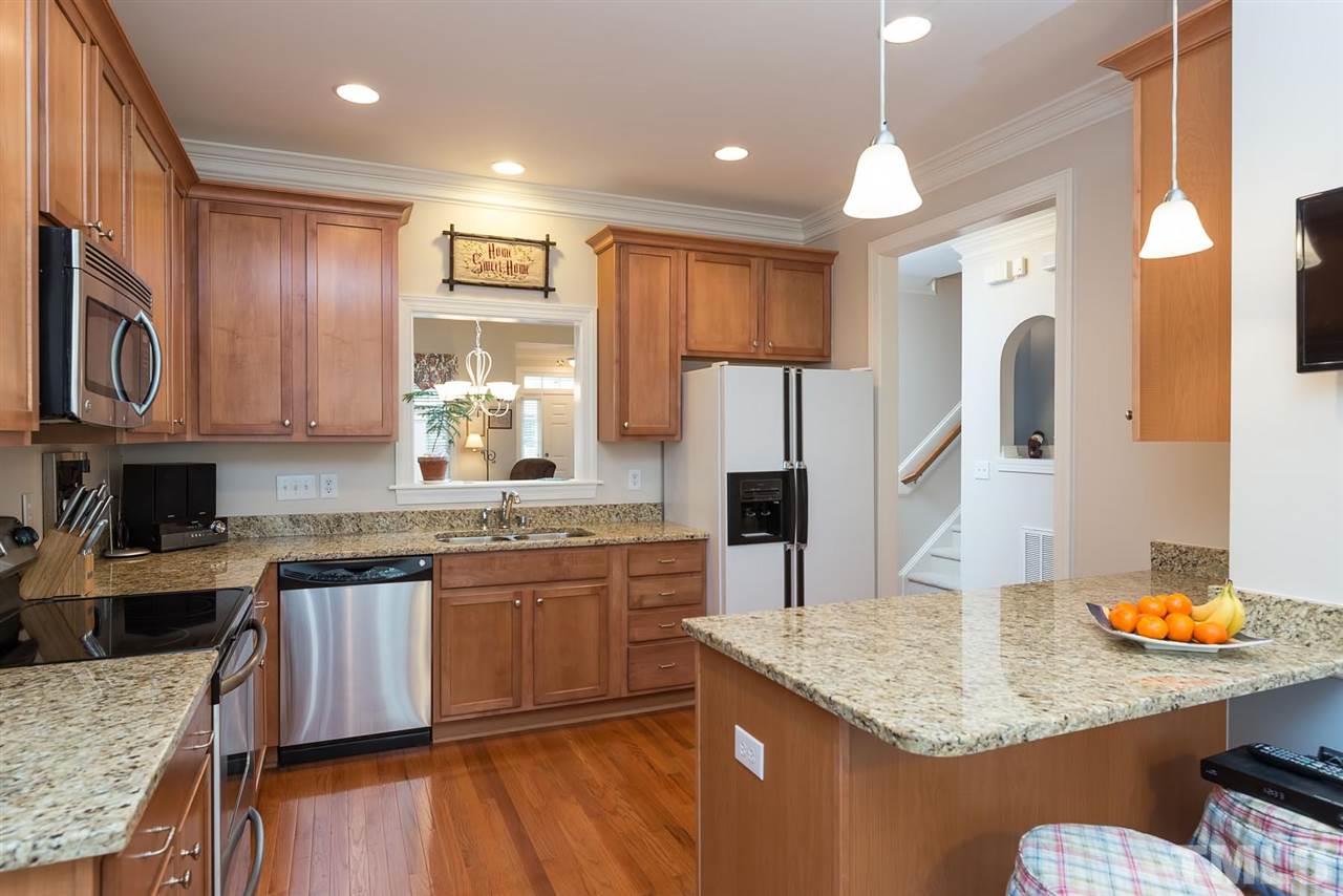 650 Democracy Street Raleigh, NC 27603 - Photo 9 of 25 a kitchen with stainless steel appliances granite countertop a sink dishwasher a refrigerator and a stove with wooden floor