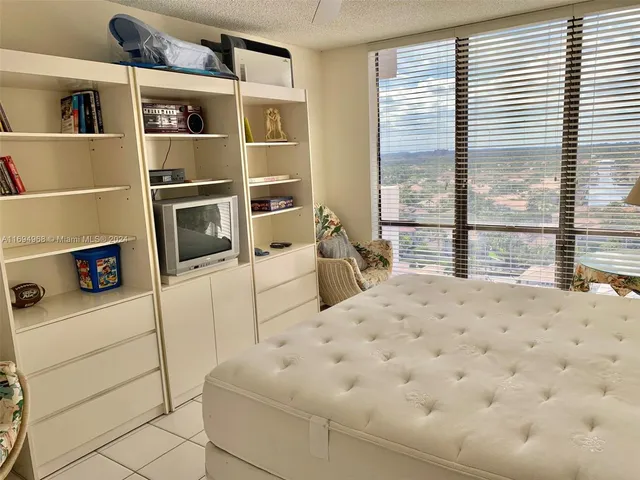 a bedroom with a bed a large window and walk in closet